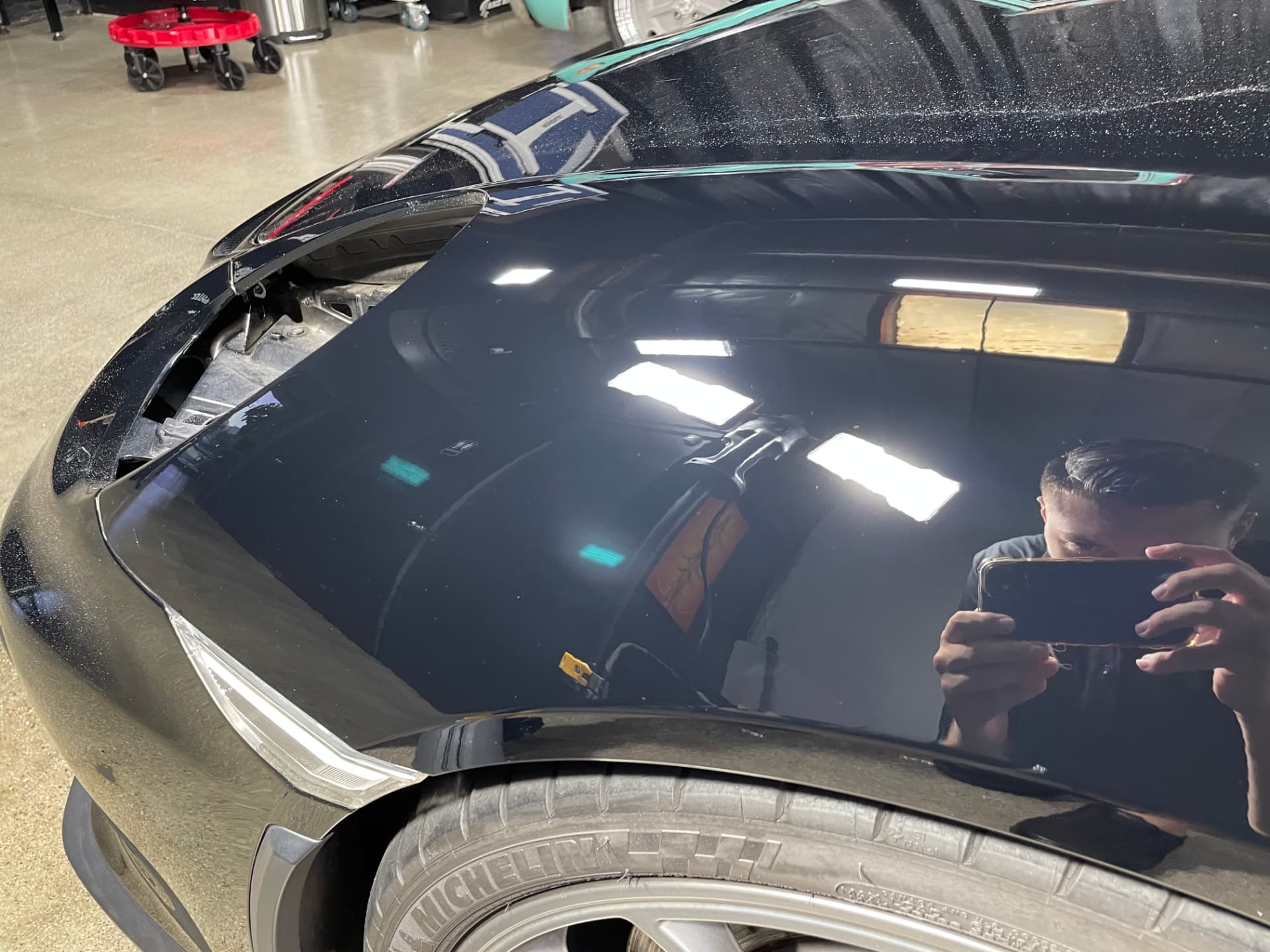 Black fender with swirl marks before and mirror-clear gloss after paint correction